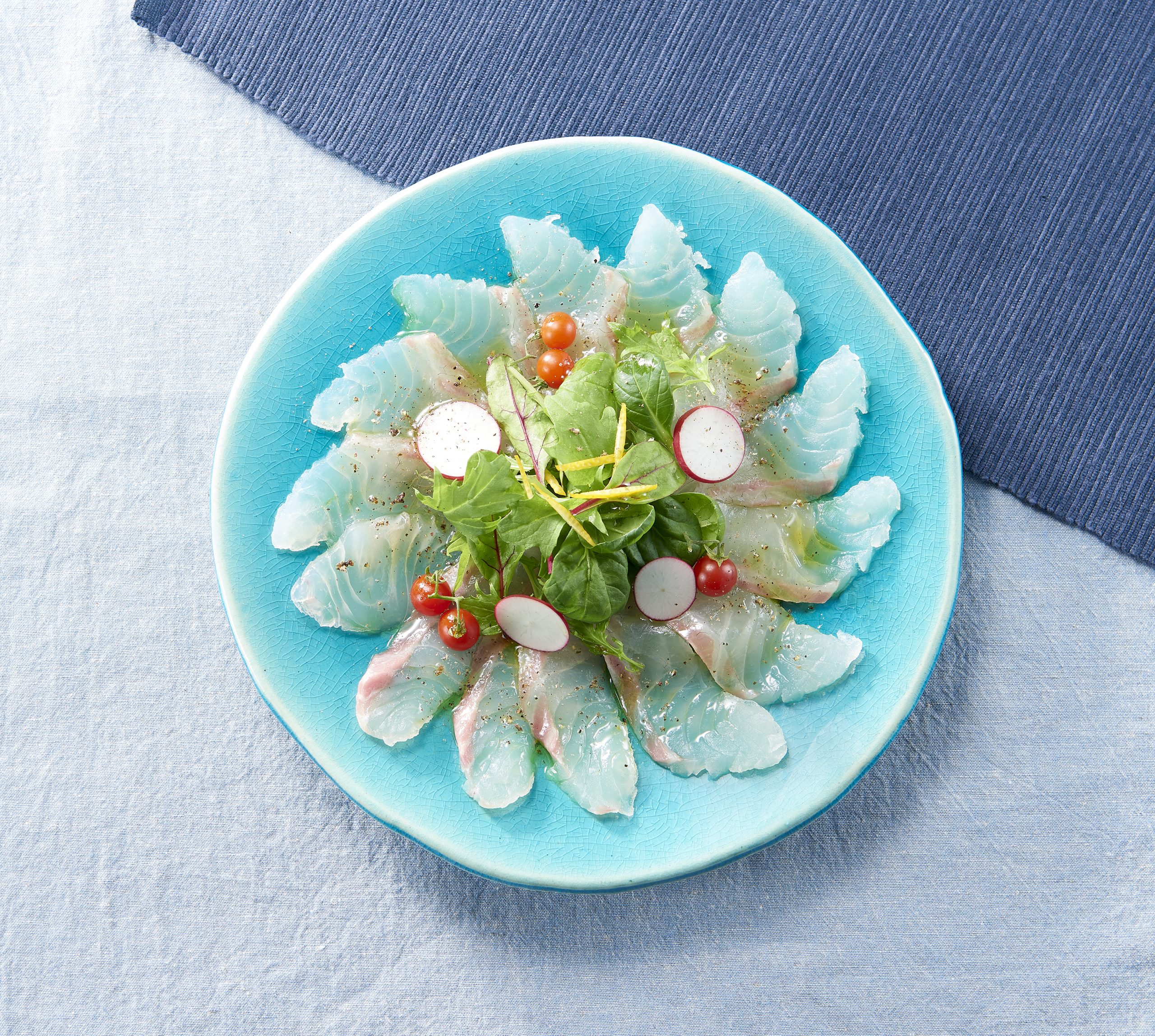 Sea bream carpaccio with baby greens, cherry tomatoes, olive oil, and Momiji Oroshi Ponzu